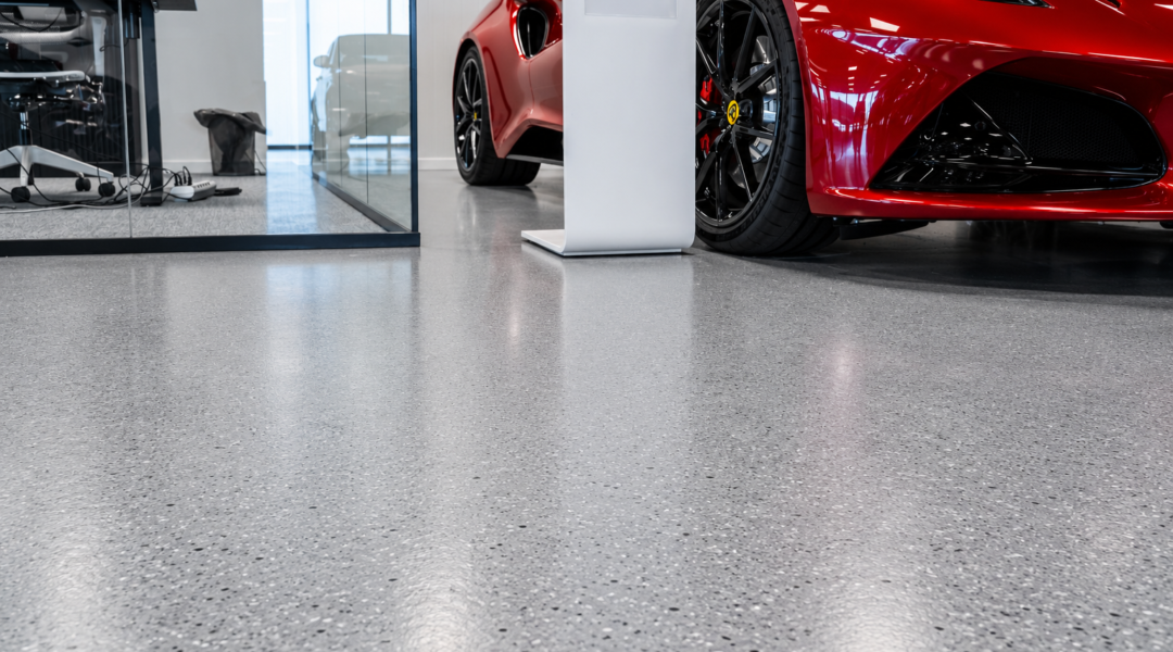 Gestorte vloer in showroom bij kantoorhoek en rode sportwagen