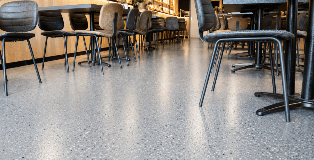 Gietvloer tussen zitplaatsen in horecazaak Gepolijste gietvloer tussen tafels en stoelen in café-restaurant