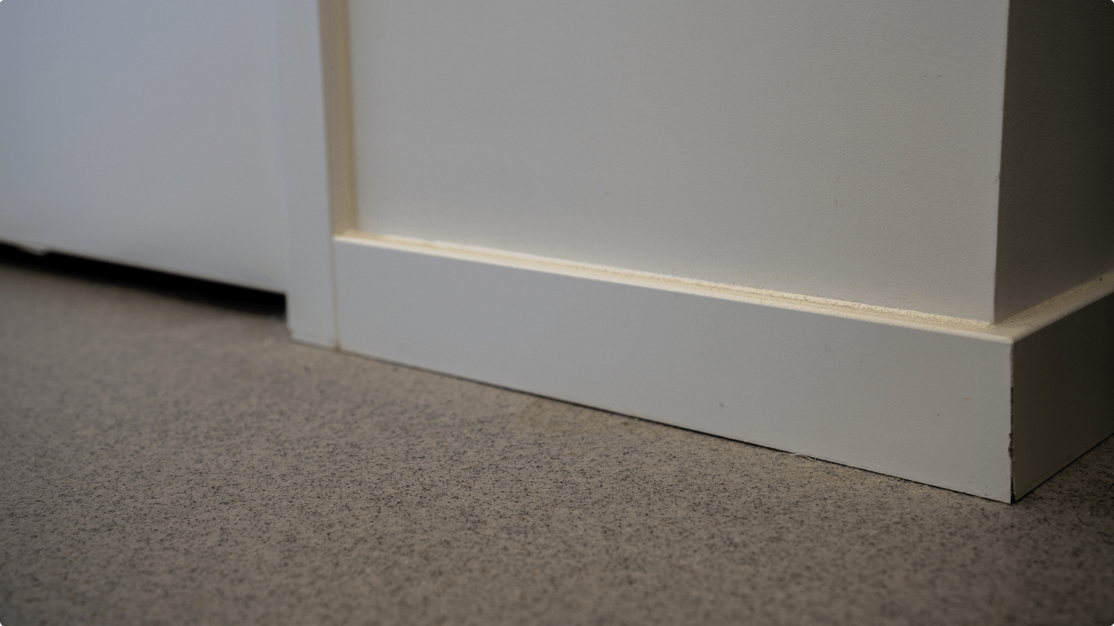 Aansluiting van de DuraQuartz kantoorvloer op een witte houten plint