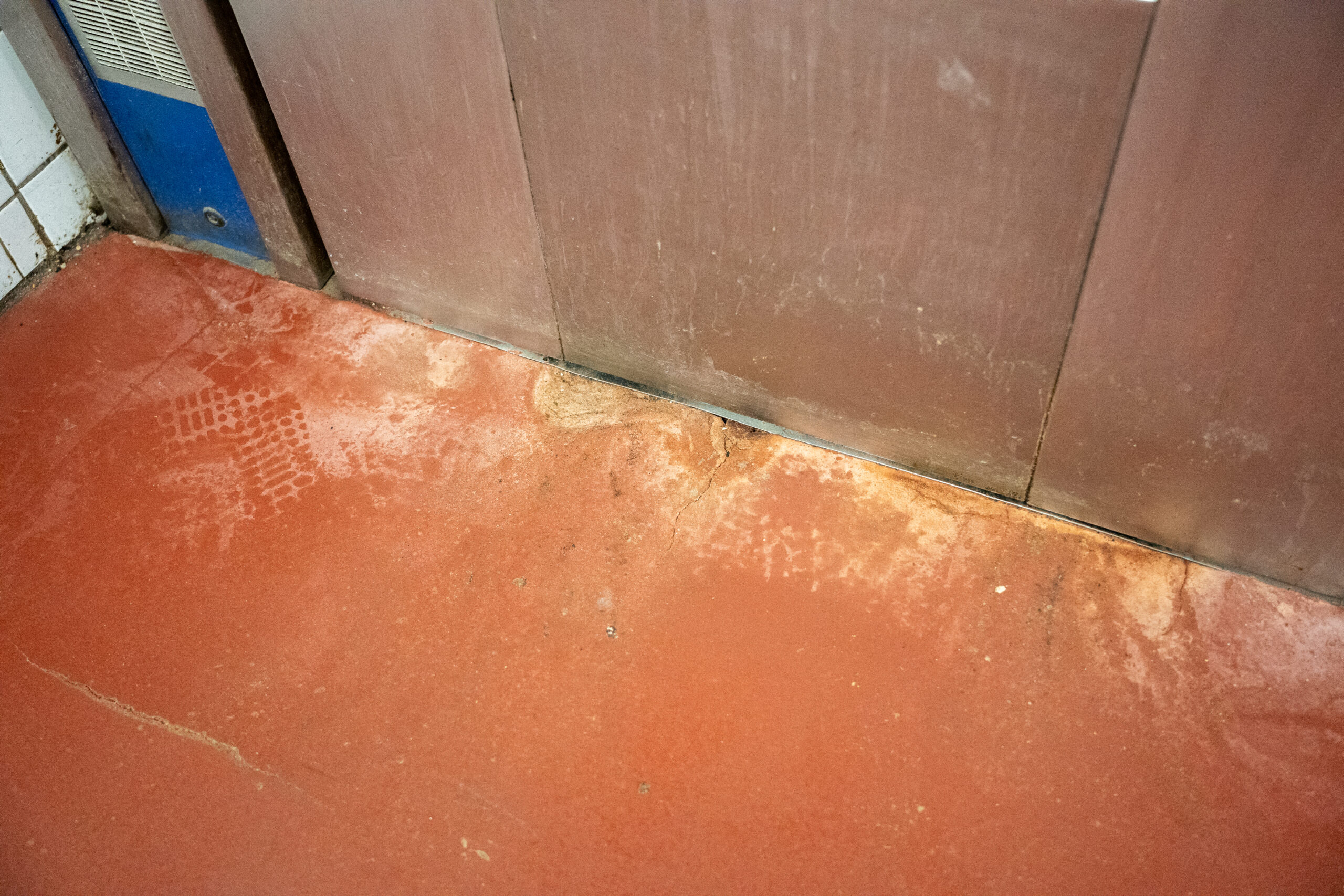 Bakkerijvloer inspectie Versleten bakkerijvloer met scheuren tijdens een vloerinspectie voor renovatie