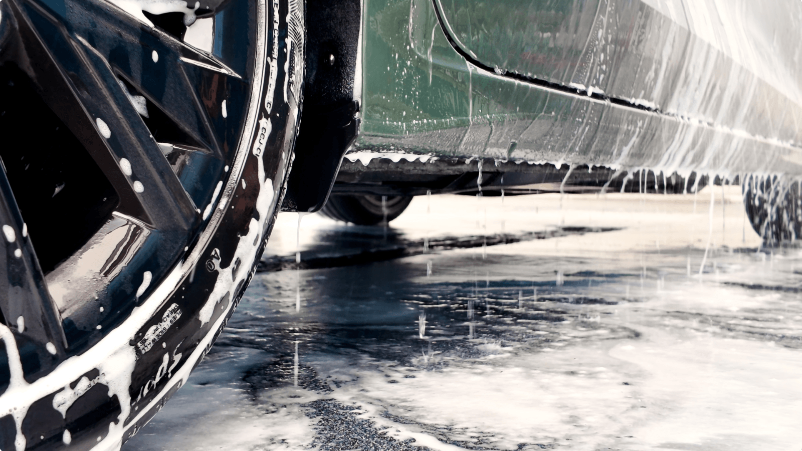 Auto met schuim op een chemie- en waterbestendige Duraquartz Torffelvloer in de wasstraat van TipTop Carwash