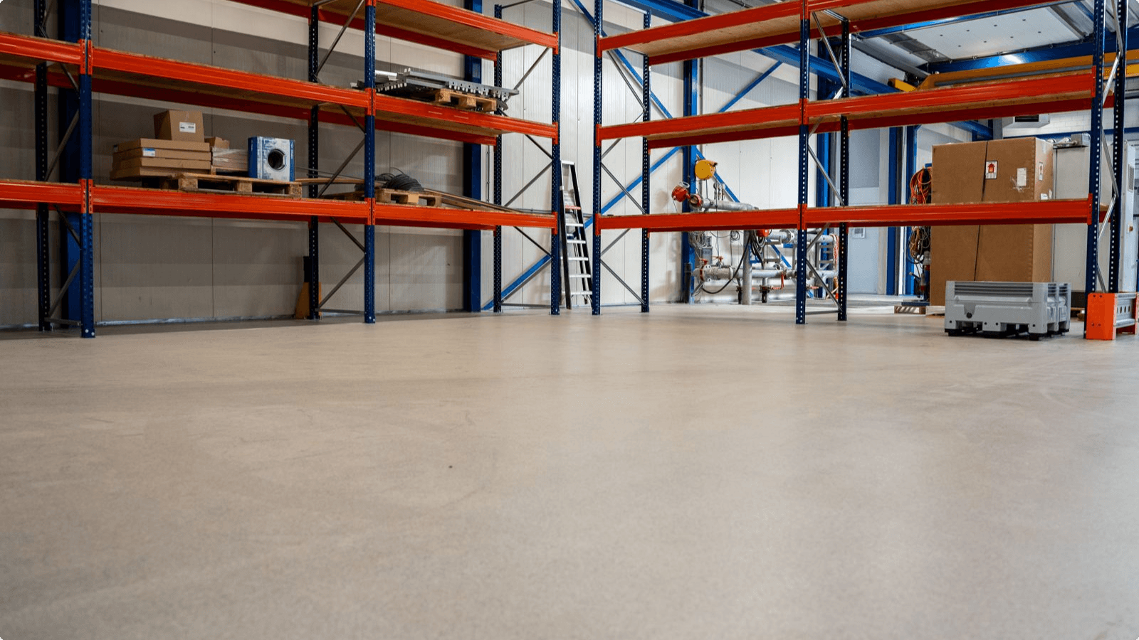 Werkplaats van Distrimex Pompen & Service met grijze DuraQuartz troffelvloer en palletstellingen