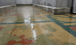 Gladde, natte vloer in koelcelgang met smeltend ijs Natte, spiegelgladde koelcelvloer in geel, groen en rood, met dooiwater dat over het oppervlak stroomt