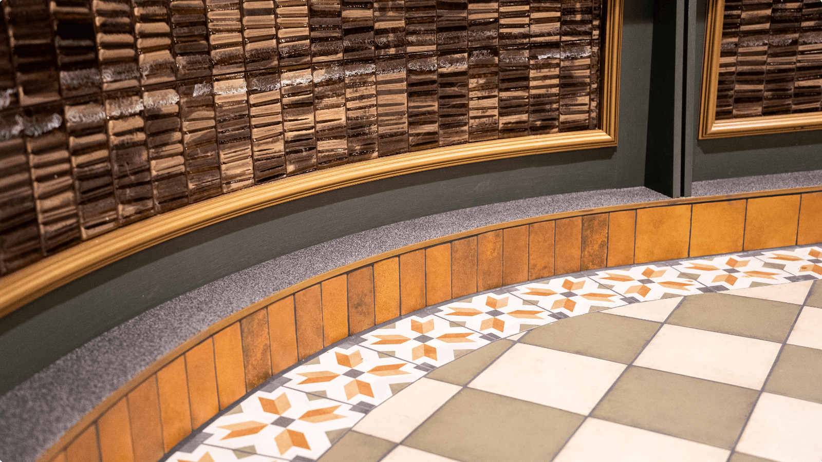 DuraQuartz troffelvloer langs de ronde bar met koperkleurige tegels in het restaurant van Intratuin Duiven