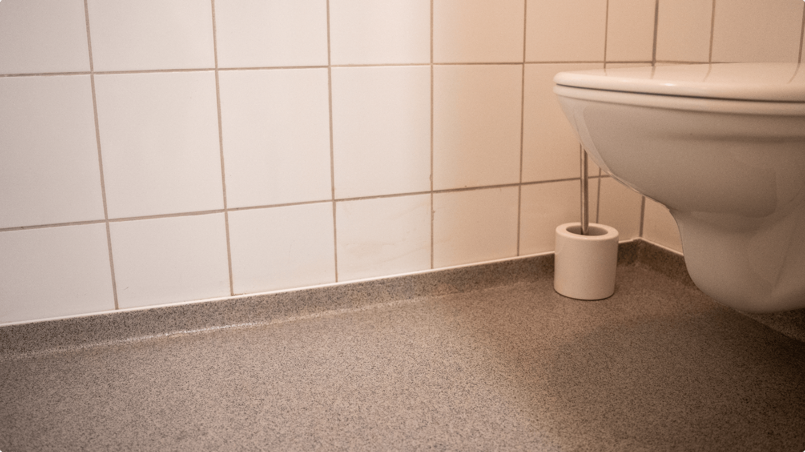 Toiletruimte met gietvloer en opstaande plint langs de betegelde wand